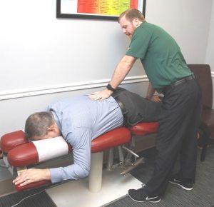 Dr. Matthew Lowry, DC Helping A Patient With A Back Injury