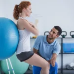 Patient Exercising With A Medical Ball At The Chiropractors Office