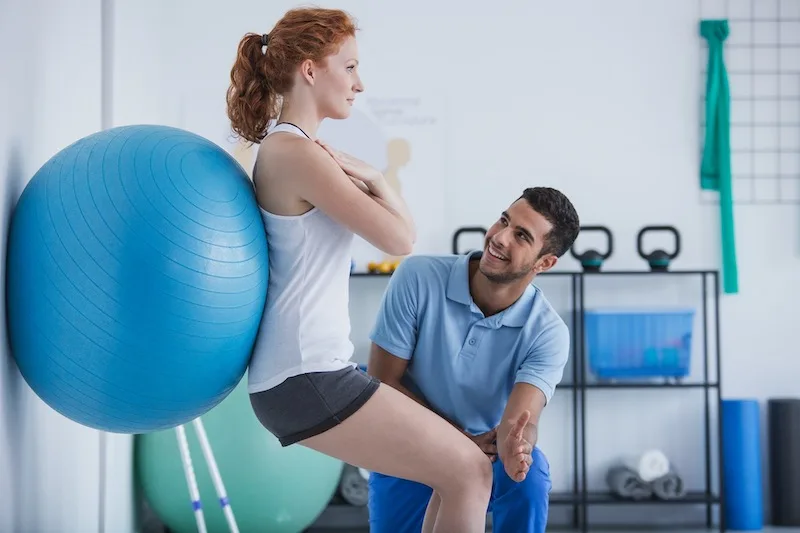 Patient Exercising With A Medical Ball At The Chiropractors Office