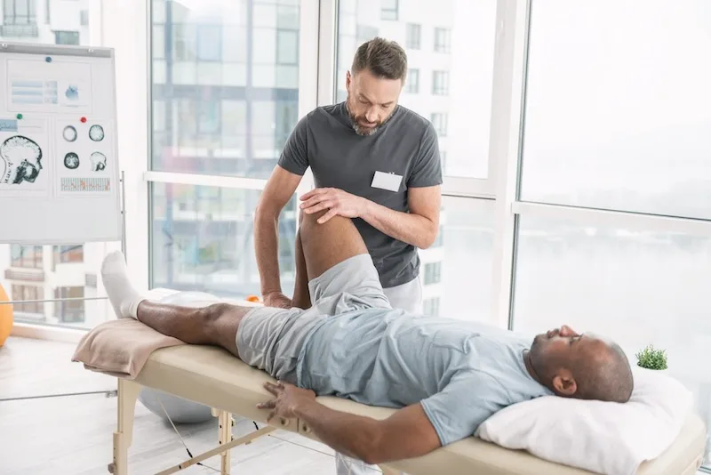 Chiropractor Stretching A Patients Leg